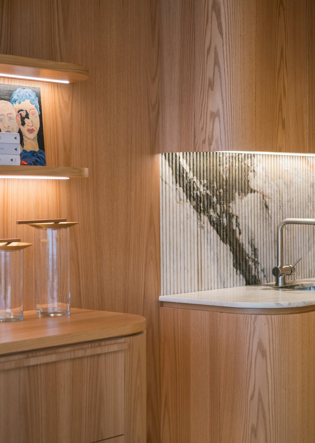 Modern kitchenette with wooden cabinets and a marble countertop.