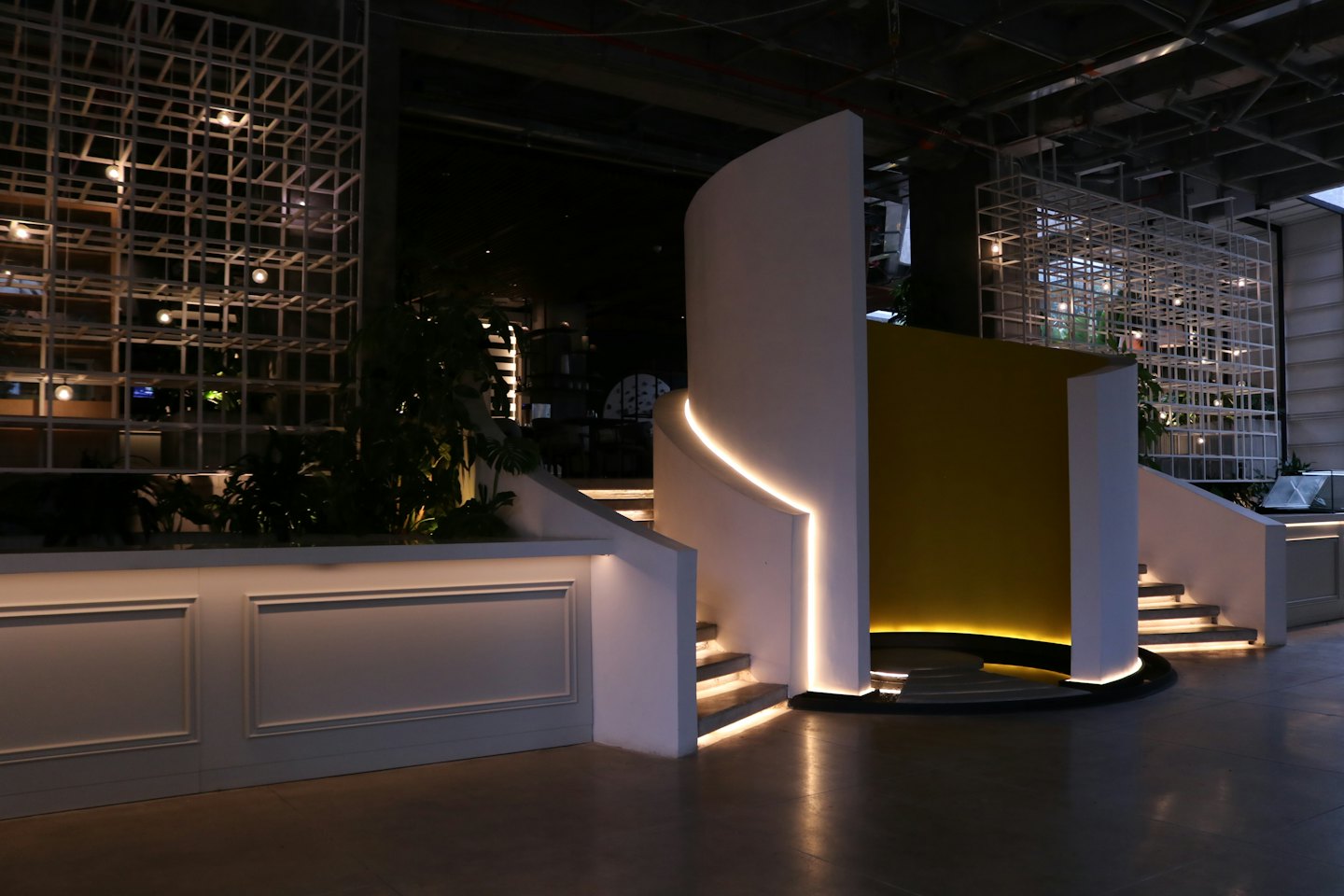 Modern office interior with curved walls and illuminated steps.